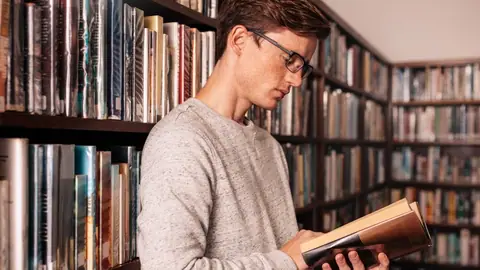Studen szuka dobrej ksiązki w bibliotece