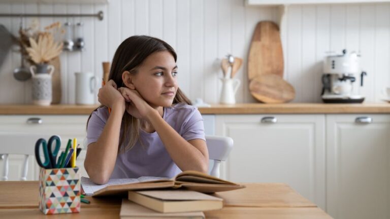Nastolatka z ksiązką w kuchnii